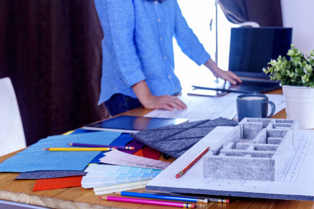 Architect -Interior designer (Artist creative) working with architecture model, material sample, laptop in office / Renovation, decoration & Real estate business conceptual