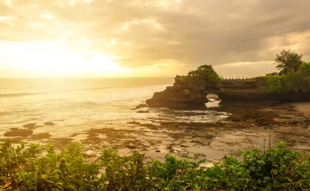 Photo of Beautiful sunset view of Pura Batu Bolong an iconic Hinduism sea temple nearly Tanah Lot temple in Bali island of Indonesia.