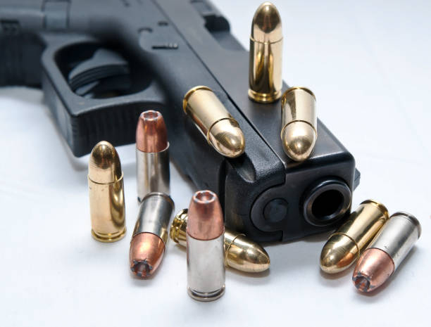 istock A black semiautomatic 9mm pistol with ten bullets on and around it 1090721014