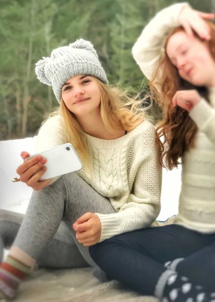istock Preteen best friend winter picnic, using technology for fun 1090732252
