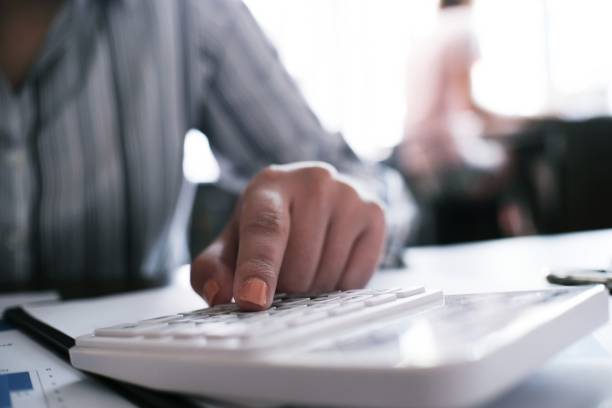 istock Business woman analyzing investment charts and pressing calculator buttons over documents. Accounting Concept. 1090734082