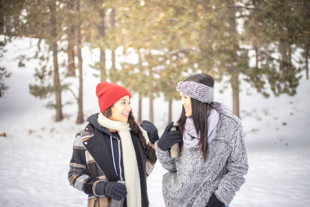 Two woman on a winter vacations playing in the snow.