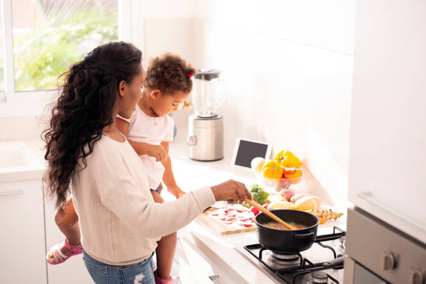 istock Mother and daughter cooking a soup at kitchen. 1090736780