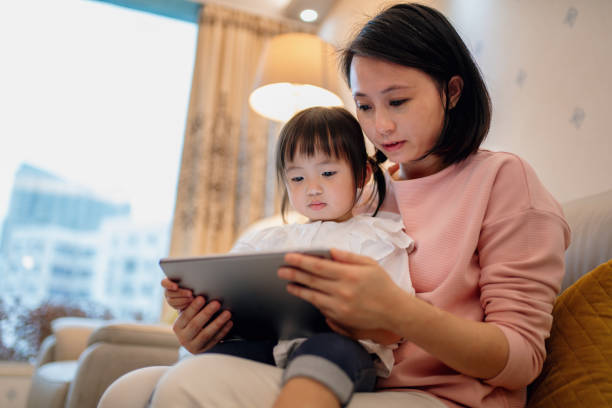 istock Young mother teaching her daughter with a digital tablet 1090737810