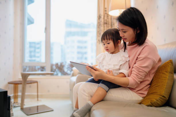 istock Young mother teaching her daughter with a digital tablet 1090737822