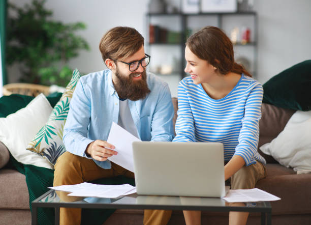 istock married couple with bills receipts documents and laptop at home 1090739286