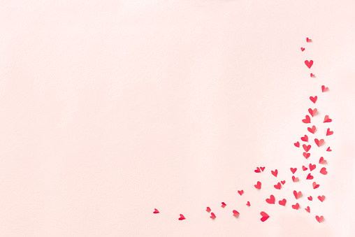 Red hearts on pink pastel background. Romantic love concept, Valentine day or wedding theme, copy space.