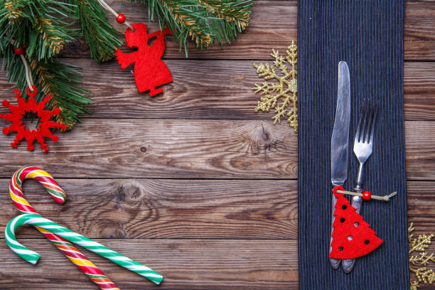 istock Christmas table place setting with fork and knife, decorated christmas toy - red fir-tree, christmas pine branches and two lollipop cane. 1090746828