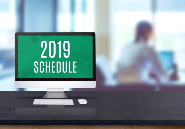istock 2019 schedule on desktop computer on black board wooden table top with blur people working at office desk bokeh background. 1090749862