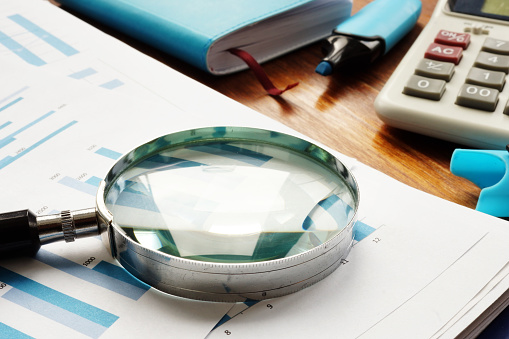 Business audit. Magnifying glass on financial documents.