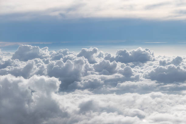 istock Above fluffy clouds with blue sky from airplane 1090759126