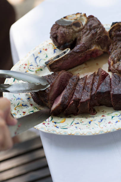 istock Hand Slicing a Big Piece of Steak on Service Plate 1090763706