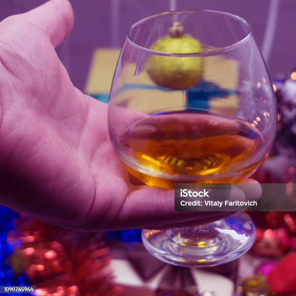 Cropped Shot Of Four People Clinking Glasses With Red Wine Over Wooden Table With Fairylights And Merry Christmas Card Stock Photo - Download Image Now