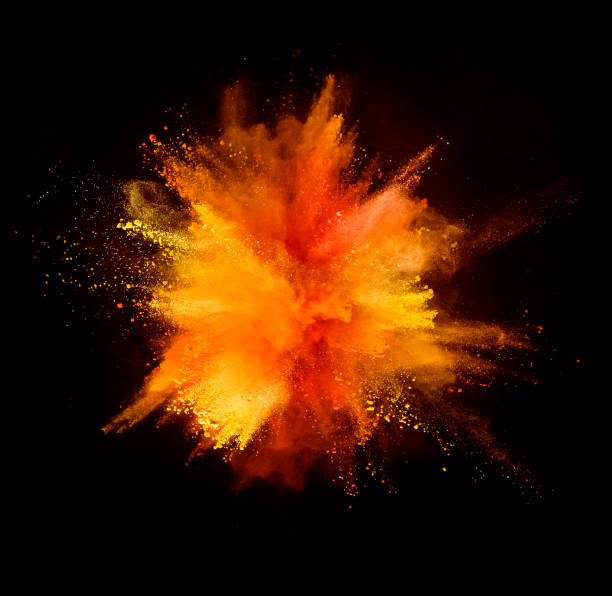 explosión de polvo de colores sobre fondo negro - naranja color fotografías e imágenes de stock