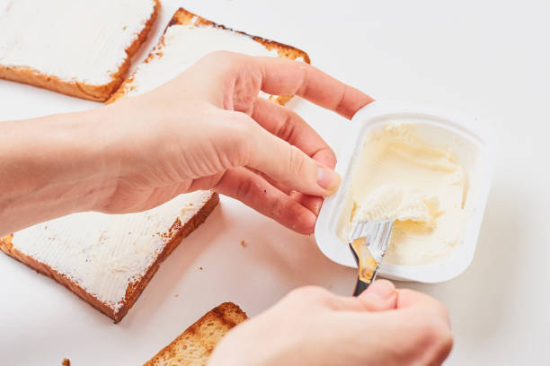 istock Woman hand make sandwich, spred toasted bread with a cheese 1090773026