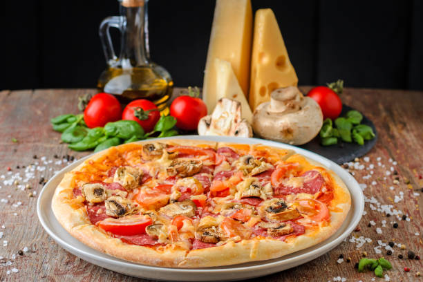 Pizza with ingredients on wooden background, close up