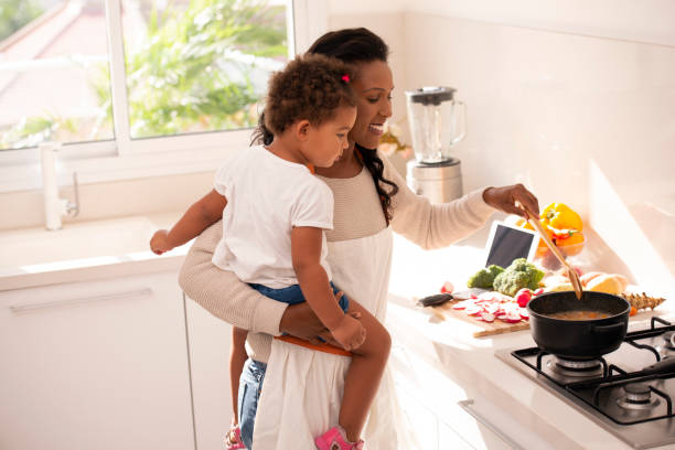 istock Mother and daughter cooking a soup at kitchen. 1090775266