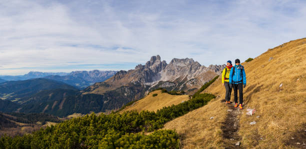 istock panoramic view hiking couple in warm outdoors sport clothes walking together on small path high up in austiran mountains 1090800922