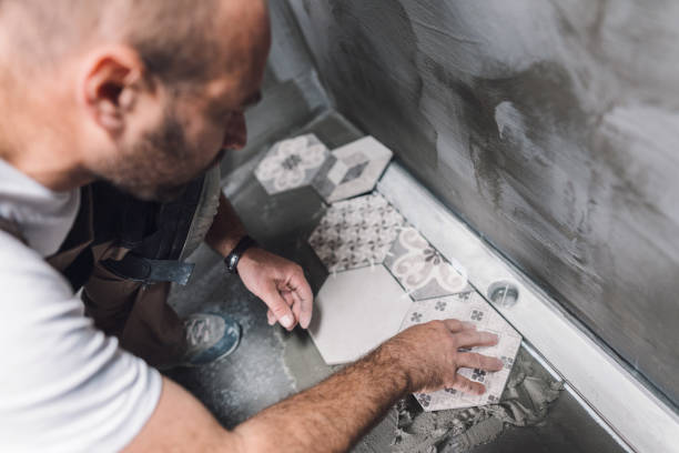 istock Tile mason laying tiles on the bathroom floor 1090801138