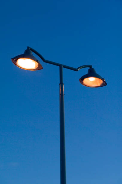 istock orange streetlamps against blue sky 1090805636