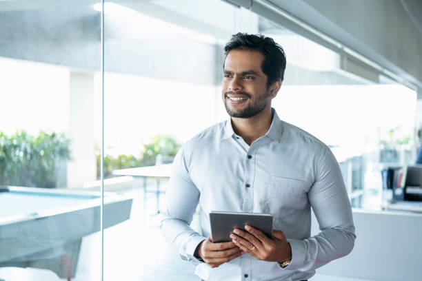 istock Young Asian businessman holding tablet and smiling 1090806534