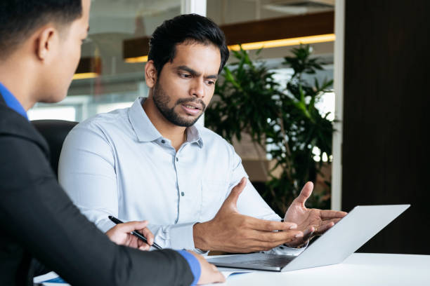 istock Young businessman explaining to colleague using laptop 1090806536