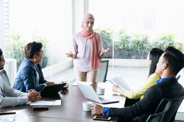istock Young woman explaining and gesturing to colleagues in meeting 1090806574