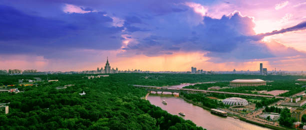 nuvole di tramonto piovoso sopra fiume, parco, ponte, navi e grande paesaggio della città di mosca - moscow russia russia river panoramic foto e immagini stock