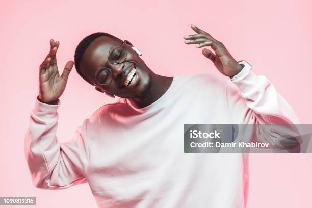 Young Handsome African American Man Dancing Singing His Favorite Song With Closed Eyes Isolated On Pink Background Stock Photo - Download Image Now