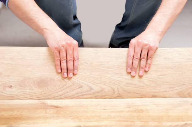 istock hands laying yellow laminate flooring 1090825866