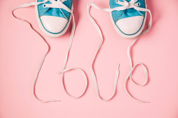 핑크 바탕에 블루 신발입니다. 끈 비 문은 "사랑"을 형성 - 2503 뉴스 사진 이미지