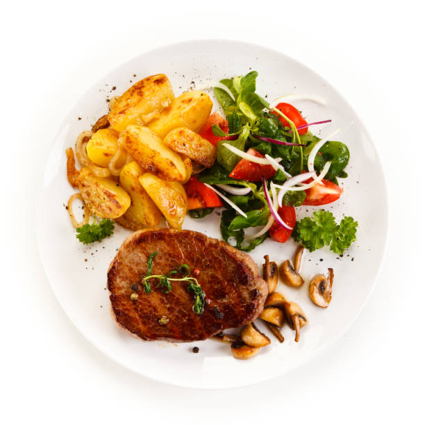 istock Grilled beefsteak, baked potatoes and vegetables on white background 1090830976