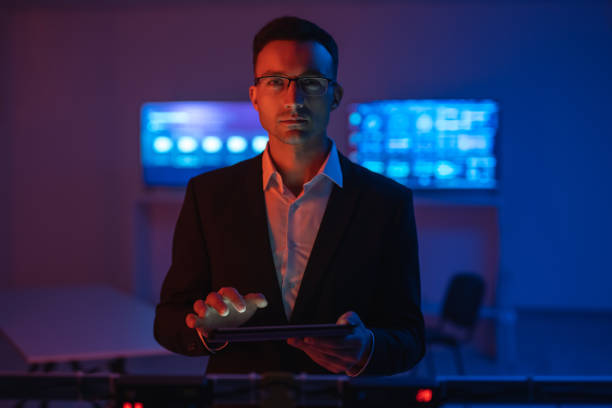 istock The man in glasses with a tablet working in a room with screens 1090835746