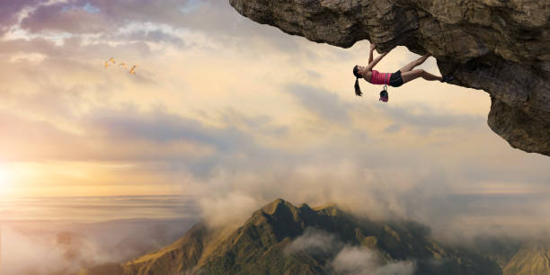 frau frei kletterer klettert überhang hoch über berge im morgengrauen - risk mountain climbing climbing conquering adversity stock-fotos und bilder