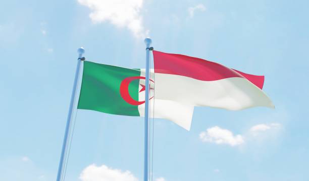 istock Algeria and Indonesia, two flags waving against blue sky 1090855824
