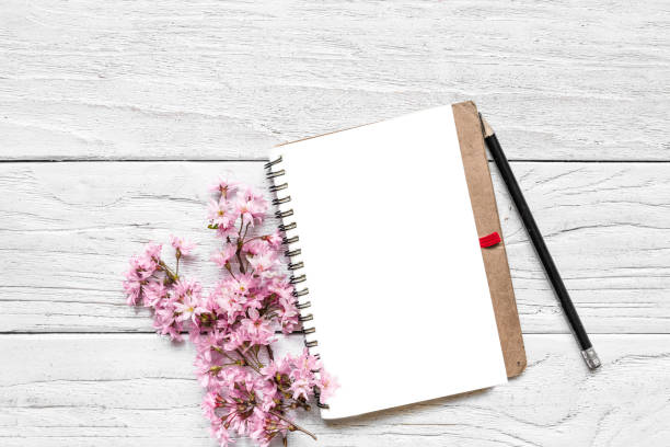 istock mock up blank paper notebook with pink blossoming spring branches of cherry with copy space. top view 1090872206