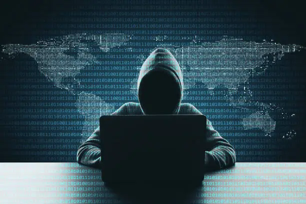 Hacker using laptop on abstract binary code map background. Hacking and phishing concept