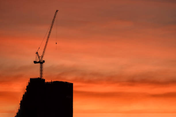 istock Silhouette crane and building construction at dusk 1090873452