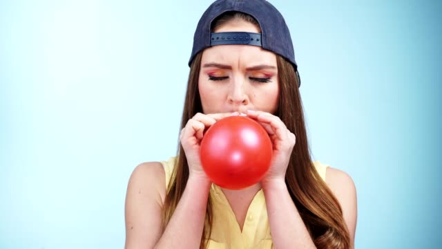 Woman casual style blowing up a red balloon 4K