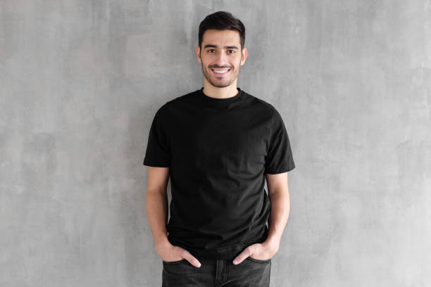 макет тела молодого человека в пустой черной футболке изолированы на текстурированном сером фоне стены - letter t фотографии стоковые фото и изображения