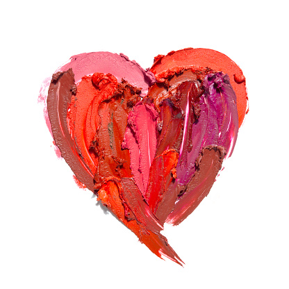 Creative concept photo of cosmetics swatches in the shape of heart love  on white background.