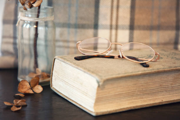 istock Vintage style ladies reading glasses and old book 1090885778