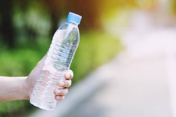 istock close up young man Hand holding fresh drinking water bottle from a plastic in the park. 1090893206