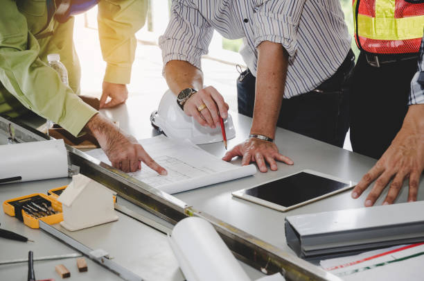 istock construction worker team planning about building plan with blueprint, safety helmet, construction tools on conference table at construction site, contractor, business, industry, construction concept 1090894318