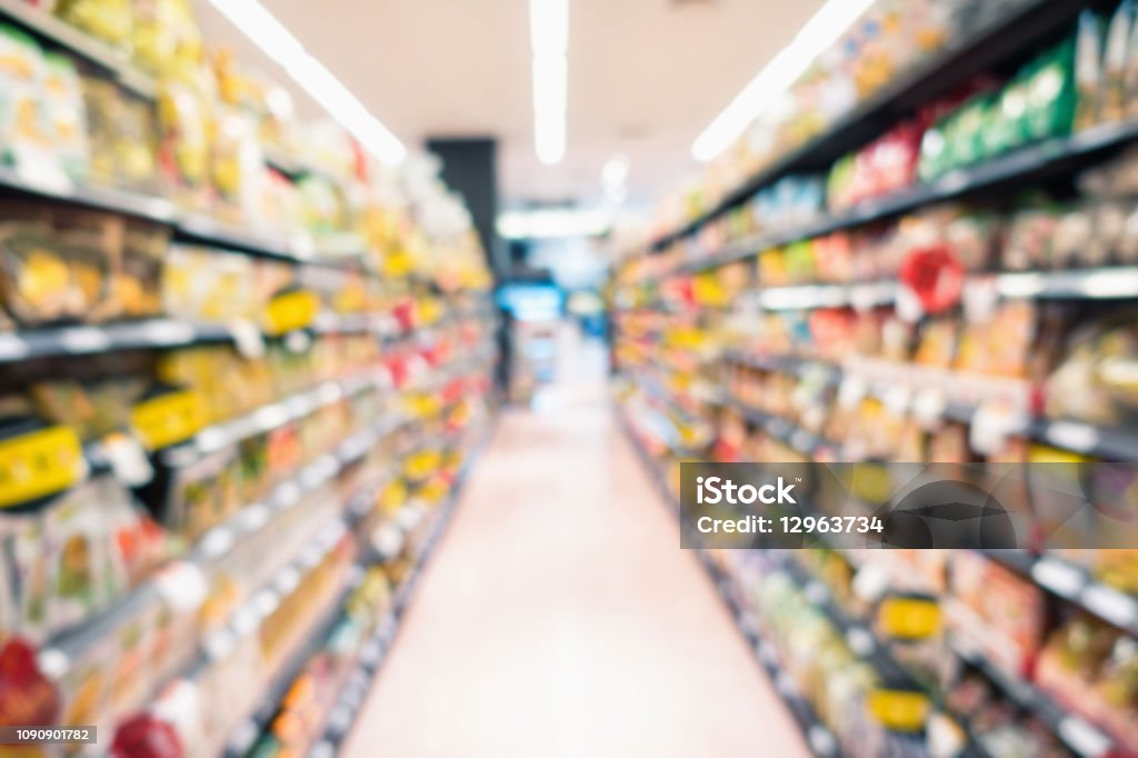 Abstract blurred supermarket grocery store and refrigerators in department store.,Consumer products goods on shelf, Category of food products on defocus background., Motion blurred concept. Supermarket Stock Photo