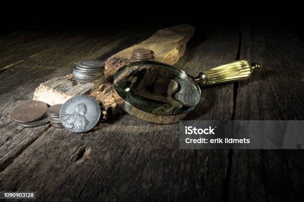 Old Coins Through A Magnifying Glasstreasure Hunting Concept In