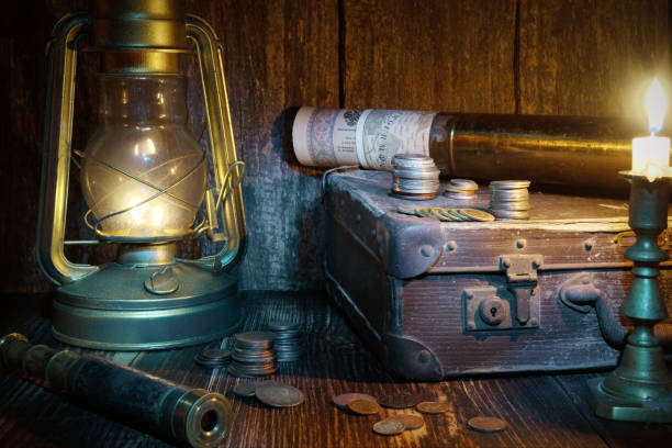 Treasure hunting. Ship lantern,old coins,monoculars, suitcase and burning candle. Marine engraving background