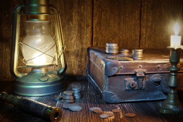 istock Treasure hunting. Ship lantern,old coins,monoculars, suitcase and burning candle. Marine engraving background 1090903418