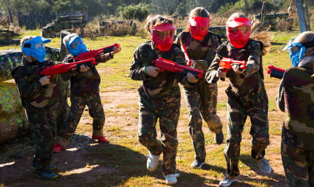 istock Opposing teams of active kids shooting paintball 1090918342