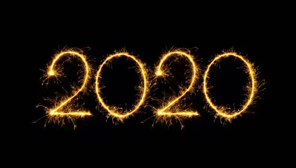 Happy New Year 2020 text handmade written sparkles fireworks. Beautiful Shiny Golden numbers isolated on black background for design